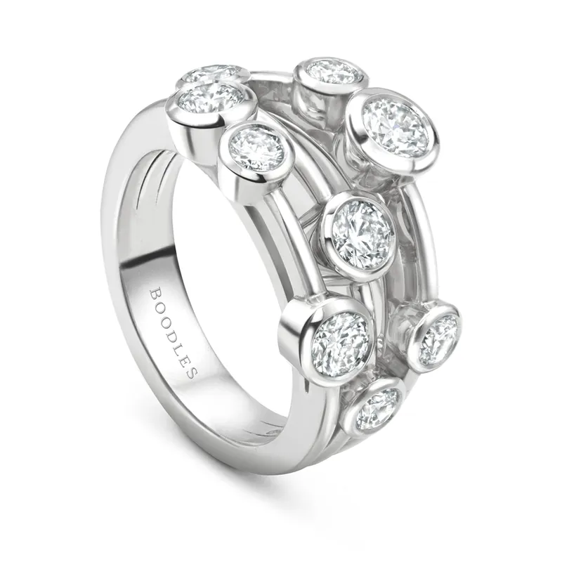 Raindance Classic ring in platinum: round diamonds of different sizes in collet settings scattered across open bands