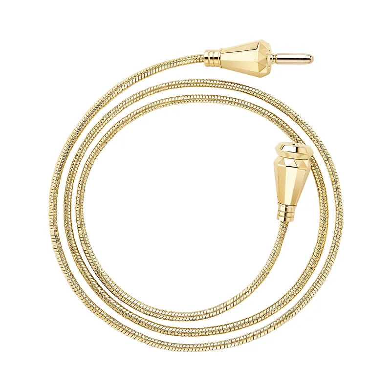 Jack de Boucheron three-turn piece in yellow gold: a coiled flexible gold cable with its faceted jack-shaped clasp ends, on a white ground.
