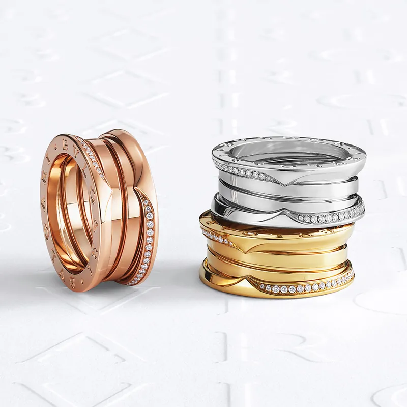 Three B.zero1 four-band rings in rose, white and yellow gold with diamond-set edges, on embossed BVLGARI paper