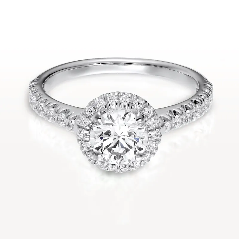 Cartier Destinée solitaire in platinum: a brilliant-cut diamond inside a halo of small diamonds on a pavé band, on a pale ground.