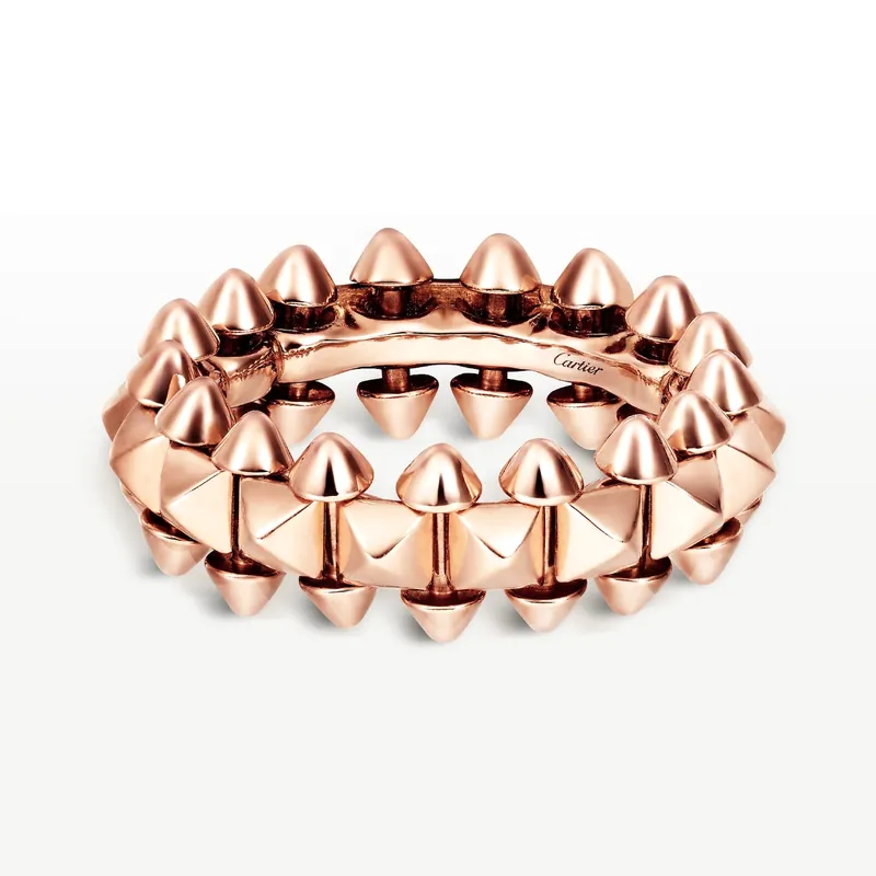 Clash de Cartier ring, medium model, in rose gold: rows of spikes around a central band of square studs, on a pale grey ground.