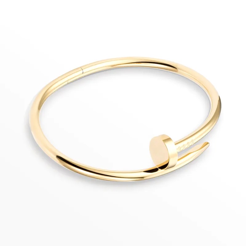Juste un Clou bracelet, classic model, in yellow gold: a nail curved into a bangle, on a pale grey ground.
