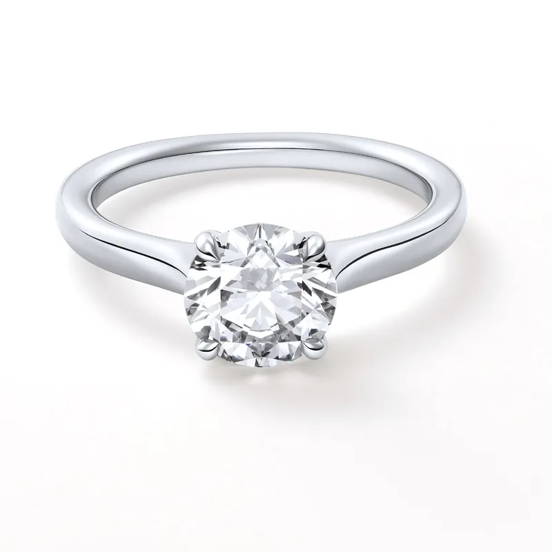 Solitaire 1895 in platinum: a brilliant-cut diamond held by four claws on a plain band, on a pale ground.