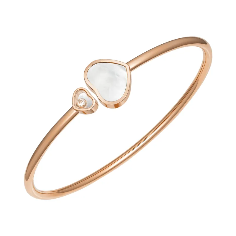 Happy Hearts bangle in rose gold: a mother-of-pearl heart beside a small open heart holding a loose diamond, on a white ground.