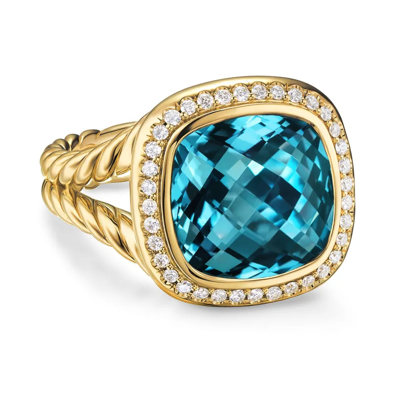 Albion ring in 18k yellow gold, 11 mm: a cushion-cut Hampton blue topaz in a frame of pavé diamonds on a split cable shank, on a white ground.