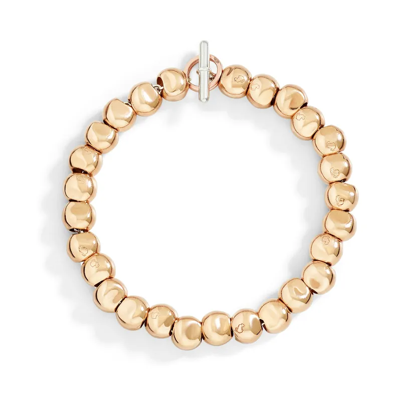 Pepita bracelet: a circle of smooth, slightly irregular rose-gold beads closed by a white-metal T-bar, on a white ground