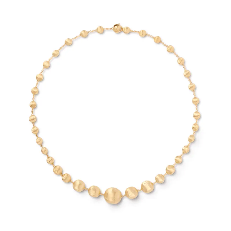 Africa necklace of graduated hand-engraved yellow-gold beads laid in a circle on an off-white ground.