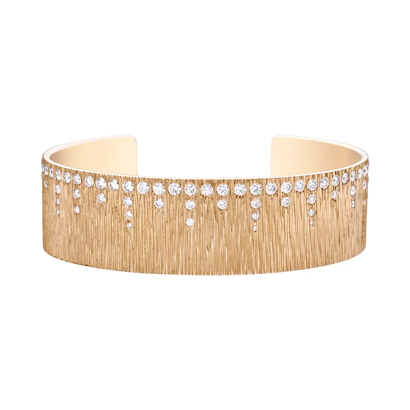 Extremely Piaget open cuff in rose gold, chased with fine vertical lines and scattered with small diamonds, on a transparent ground.