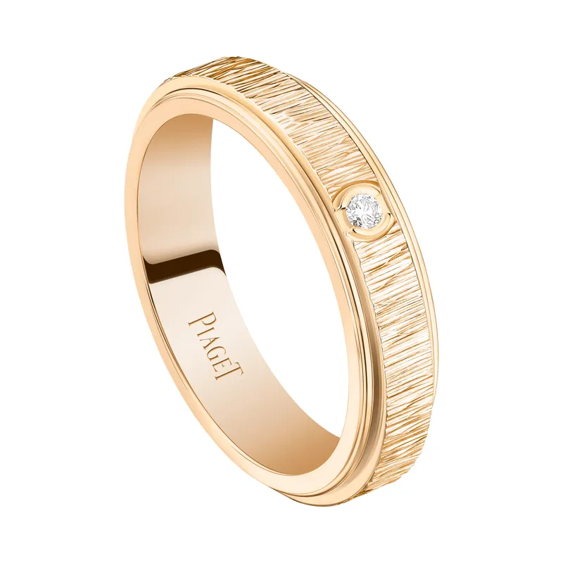 Possession ring in rose gold: a turning band chased with fine vertical lines and set with one diamond, on a transparent ground.
