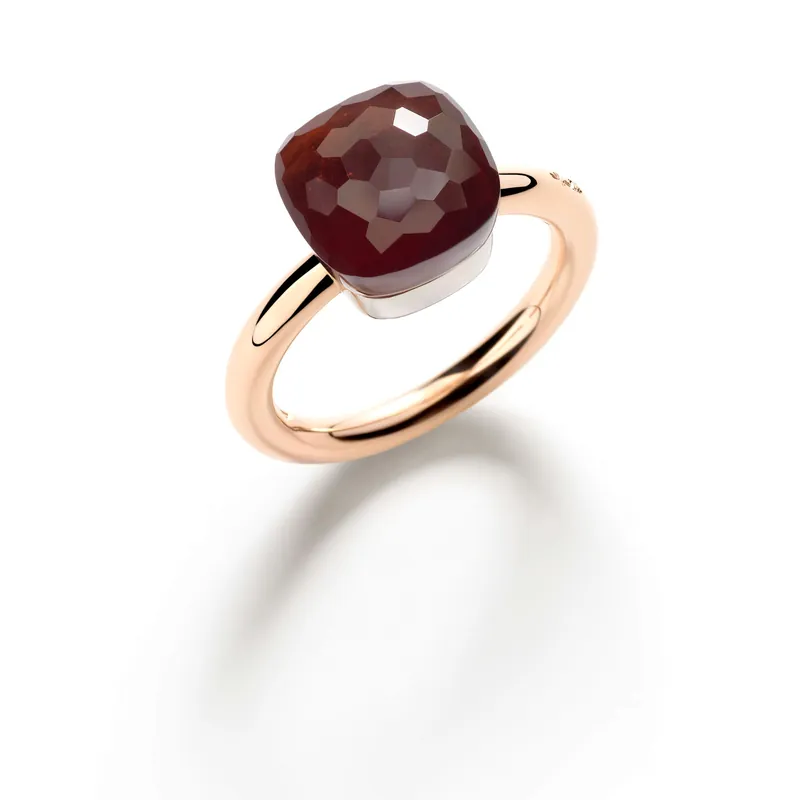 Nudo Classic ring: a square faceted garnet in a white-gold collet on a thin rose-gold band, on a pale grey ground.